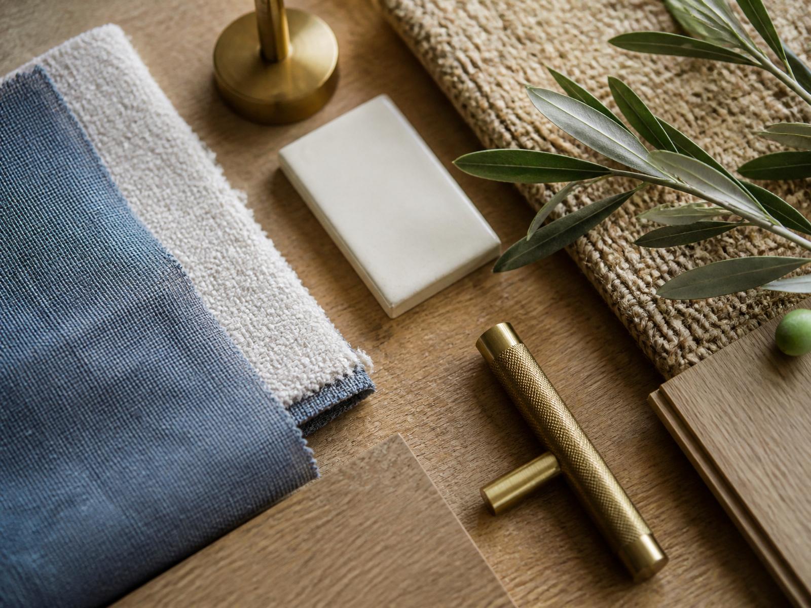 A sourcing tray with fabric swatches, oak samples, and brass hardware